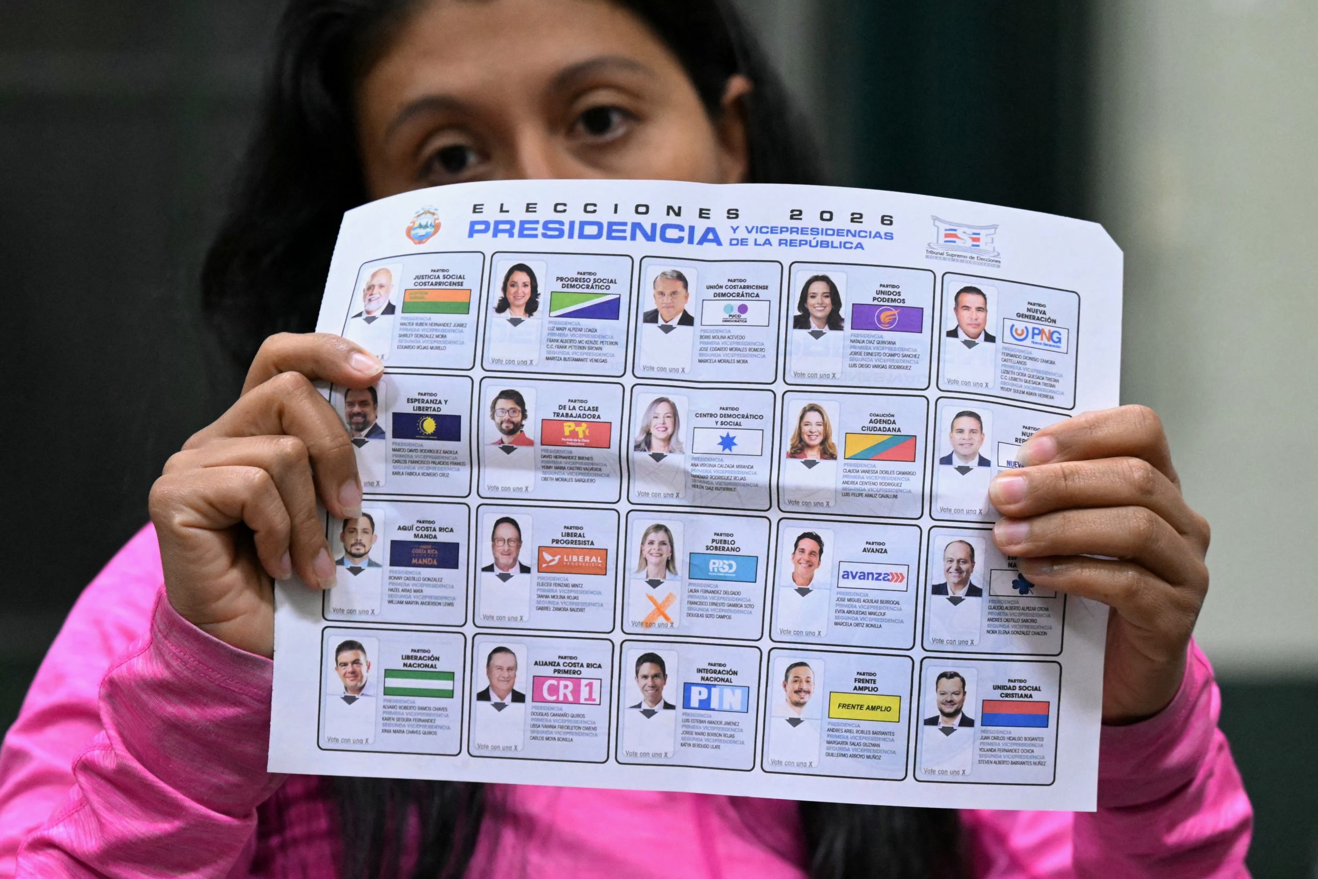 An election official shows a ballot as she counts votes after polls closed at the Pilar Jimenez school polling station during the presidential election in San Jose on February 1, 2026. Voters in Costa Rica, a beacon of stability in Central America threatened by a surge in drug-related violence, went to the polls in general elections that are expected to bring a tough-on-crime right-winger to power. (Photo by Marvin RECINOS / AFP)