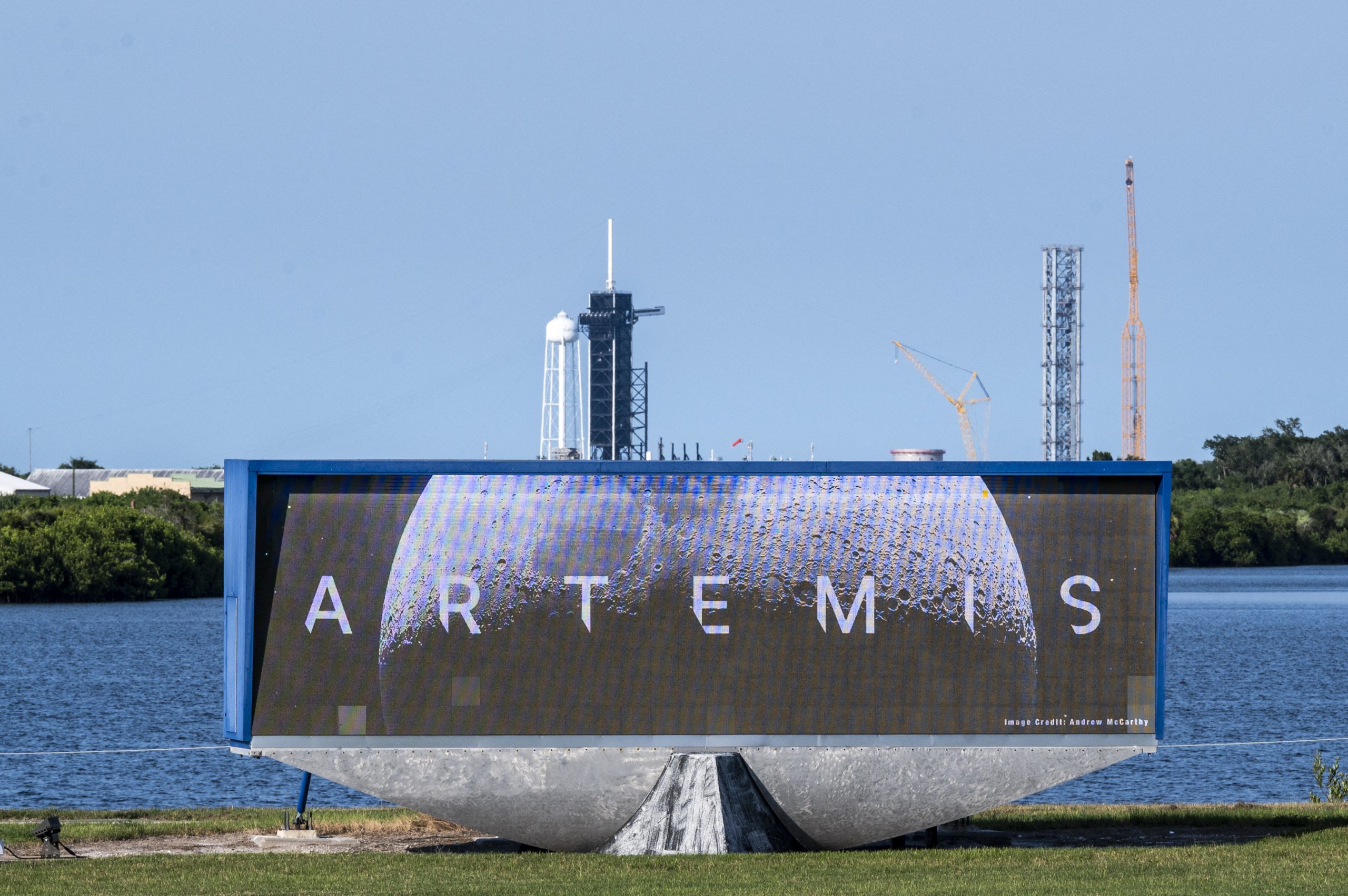 Launch Pad Complex 39B is seen behind a screen displaying NASA's Artemis I Moon logo at Kennedy Space Center, in Cape Canaveral, Florida, on August 16, 2022. Artemis 1, an uncrewed test flight, will feature the first blastoff of the massive Space Launch System (SLS) rocket, which will be the most powerful in the world when it goes into operation. It will propel the Orion crew capsule into orbit around the Moon. The spacecraft will remain in space for 42 days before returning to Earth. (Photo by CHANDAN KHANNA / AFP)