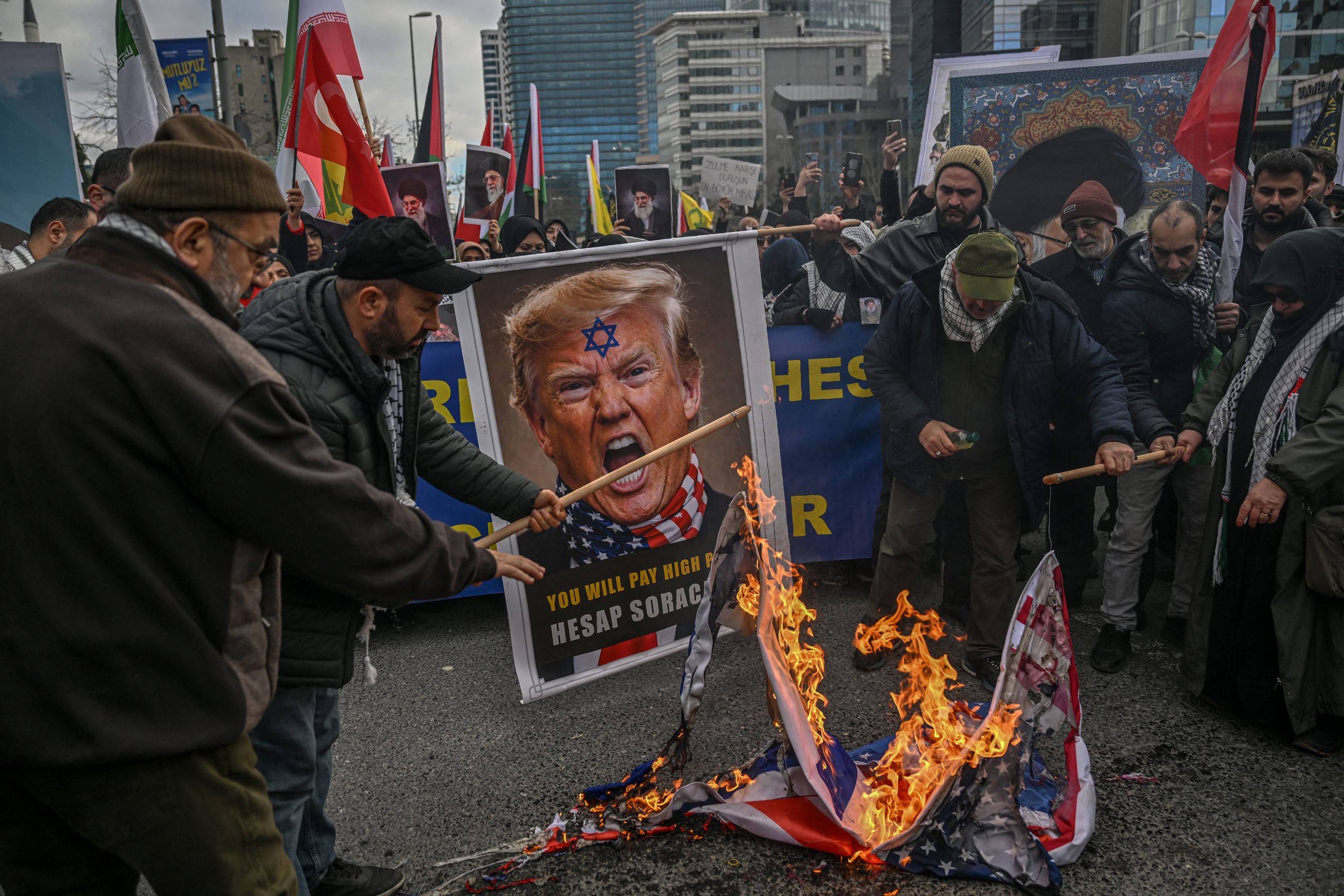 Protestors holding an image depicting US President Donald Trump set fire to a US flag as they gather to protest against the US and Israel attack of Iran and the killing of the Supreme leader in front of Israel Consulate in Istanbul on March 1, 2026. The United States and Israel launched strikes against Iran on February 28, 2026 sparking fears of regional war with explosions reported across the Middle East as the Islamic republic retaliated with barrages of missiles. (Photo by Ozan KOSE / AFP)