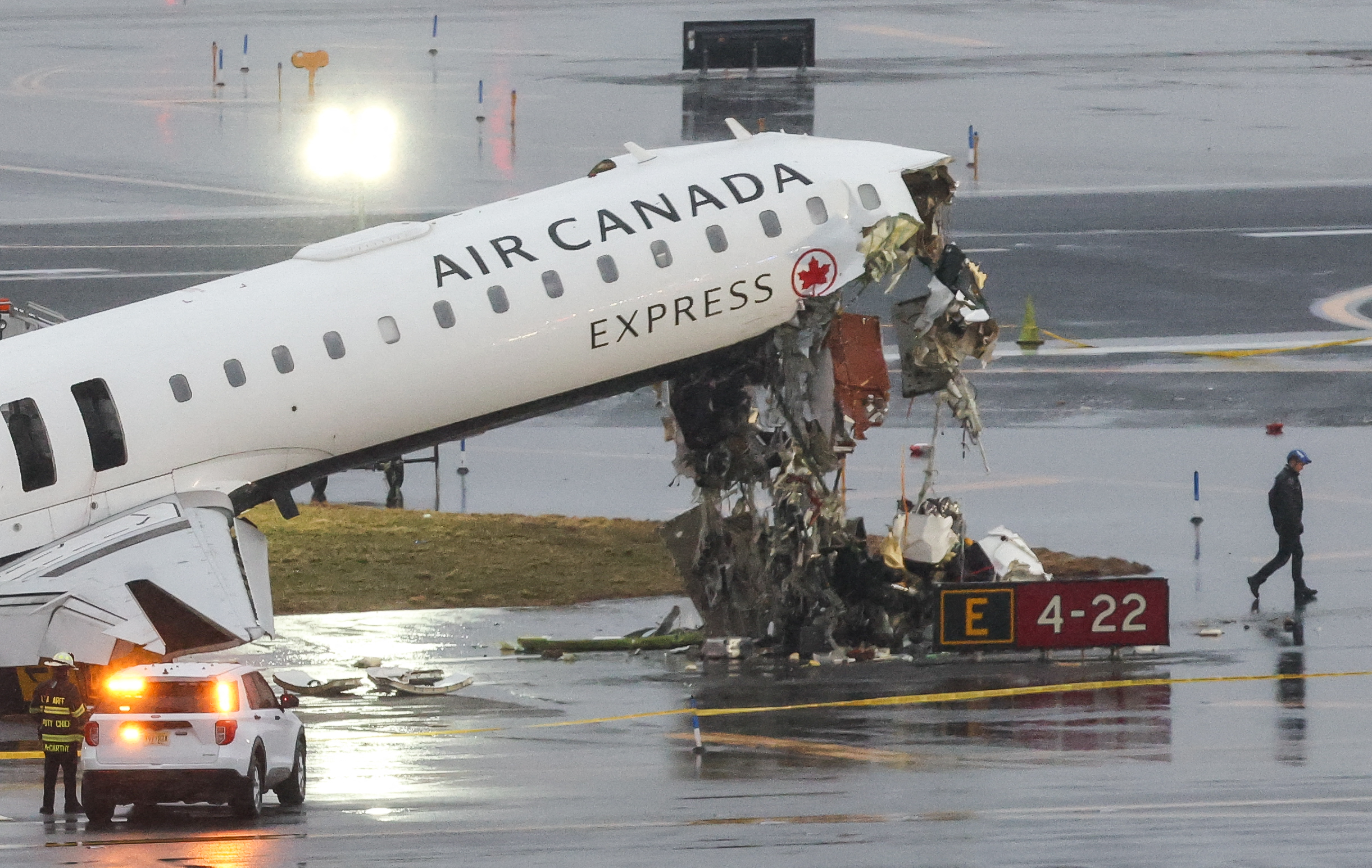 An Air Canada Express CRJ-900 sits on the runway after colliding with a Port Authority fire truck at LaGuardia Airport in New York, on March 23, 2026. A plane carrying dozens of people collided with a fire truck on a runway at New York's LaGuardia airport, killing the pilot and co-pilot and causing "serious injuries" to others, authorities said Monday. Due to the crash late Sunday, US aviation authorities halted all flights at LaGuardia, and the port authority said the airport would stay shut until at least 2:00 pm (1800 GMT) "to allow for a thorough investigation." (Photo by TIMOTHY A. CLARY / AFP)