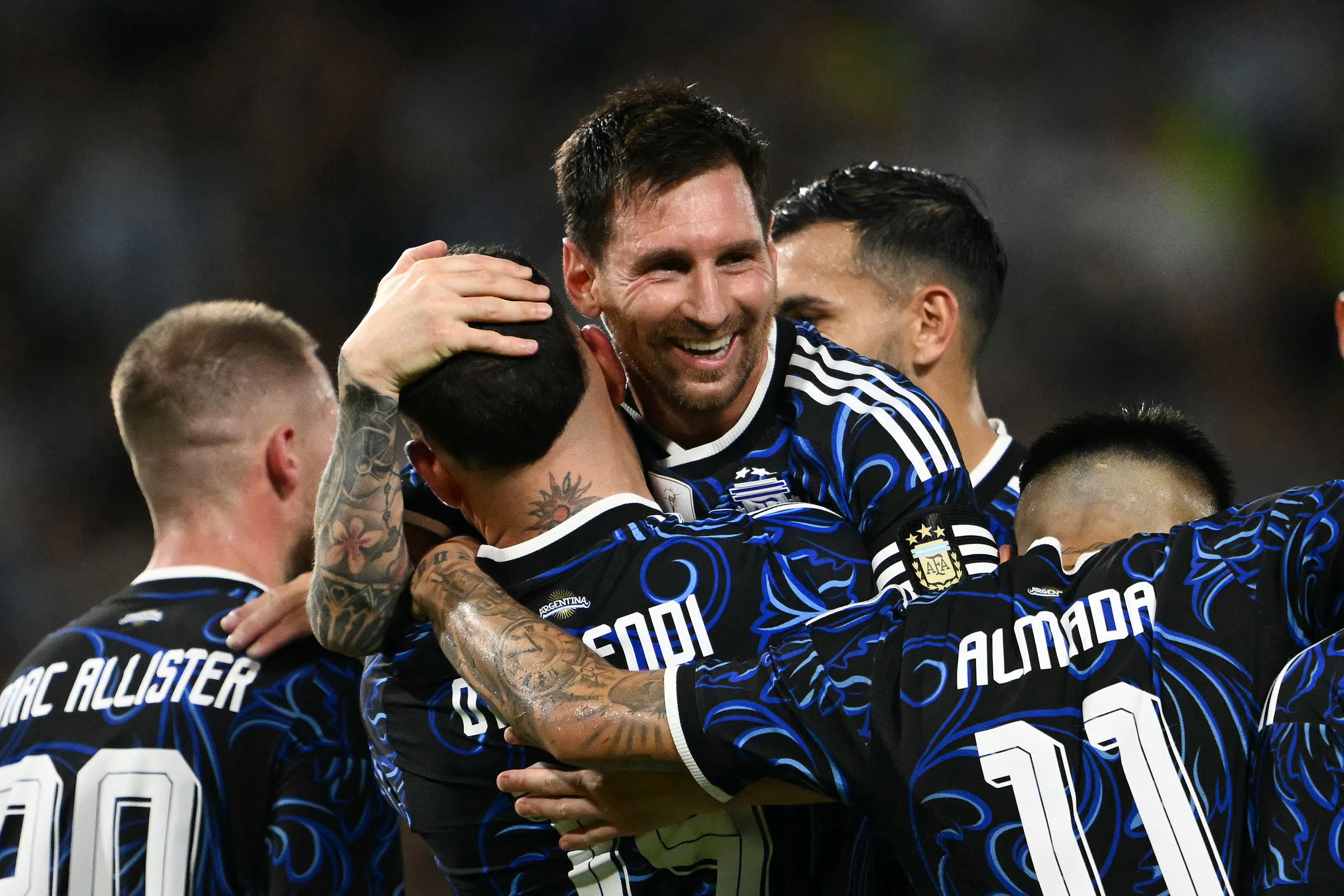 Argentina's defender #19 Nicolas Otamendi celebrates with teammate forward #10 Lionel Messi after scoring his team's third goal during a friendly football match between Argentina and Zambia at La Bombonera stadium in Buenos Aires on March 31, 2026. (Photo by Luis ROBAYO / AFP)
