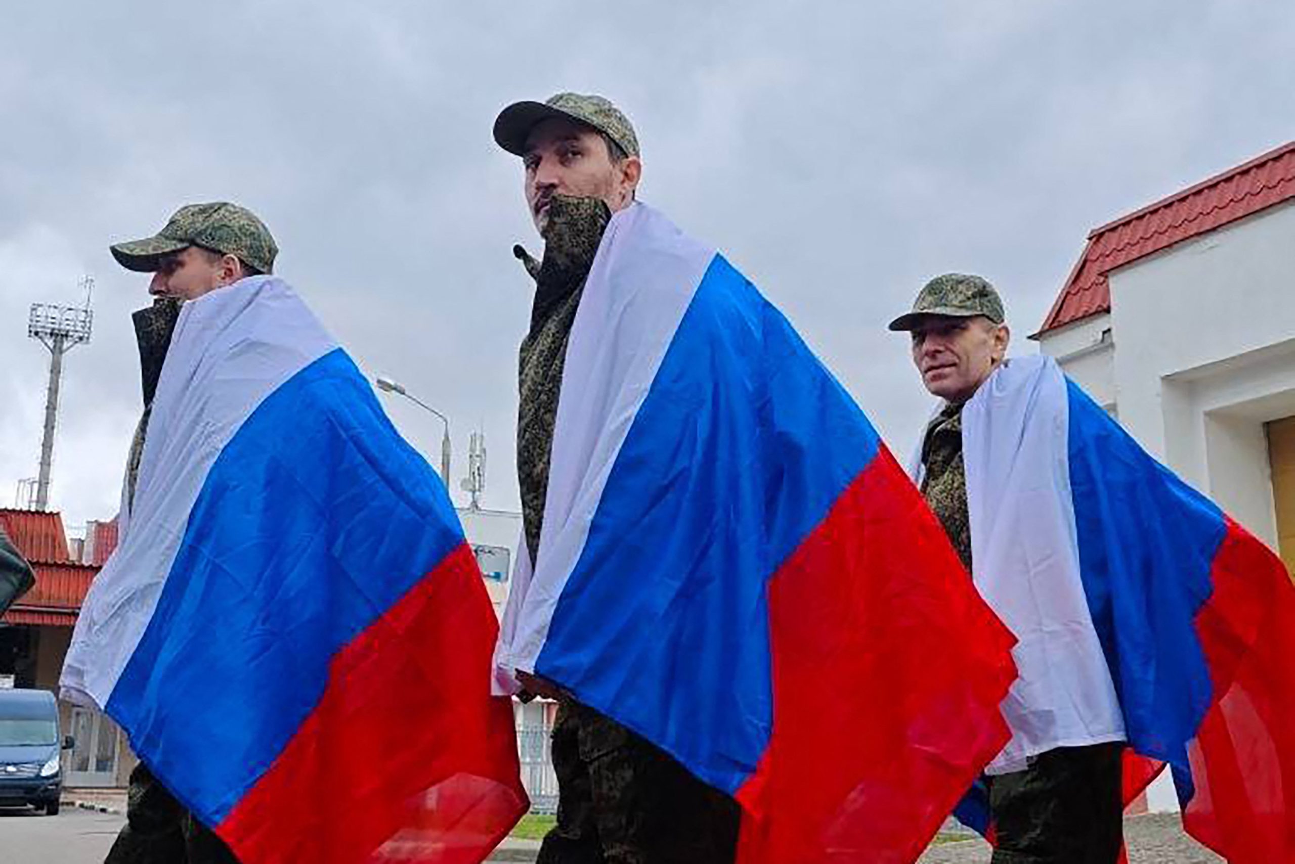 In this handout photograph posted on the official Telegram Channel of Kremlin aide Vladimir Medinsky on April 11, 2026, former Russian prisoners of war (POWs), wrapped with Russian national flags, look on following an exchange at an undisclosed location in Belarus, amid the ongoing Russia-Ukraine conflict. Russia and Ukraine swapped 175 prisoners of war each on April 11, 2026, the Russian defence ministry said, in one of the few areas of cooperation between the warring sides. (Photo by Handout / Telegram / @vr_medinskiy / AFP) / RESTRICTED TO EDITORIAL USE - MANDATORY CREDIT "AFP PHOTO / OFFICIAL TELEGRAM CHANNEL OF KREMLIN AIDE VLADIMIR MEDINSKY" -  HANDOUT - NO MARKETING NO ADVERTISING CAMPAIGNS - DISTRIBUTED AS A SERVICE TO CLIENTS - AFP CANNOT INDEPENDENTLY VERIFY THE AUTHENTICITY OR LOCATION, DATE, AND CONTENT OF THESE IMAGES. /