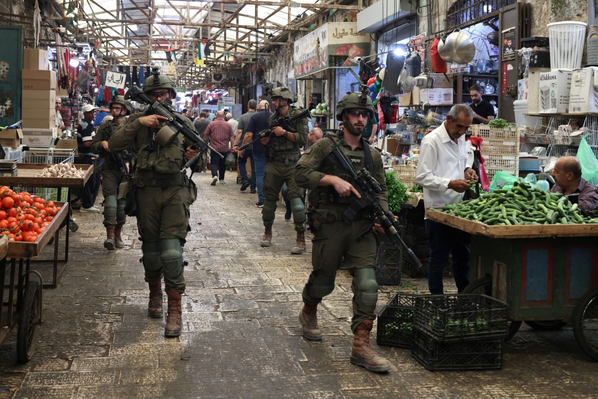 Armed Israeli soldiers carry out a foot patrol through the market, in the Old City of Nablus, in the northern Israeli-occupied West Bank on August 9, 2026. The occupied West Bank has been gripped by almost daily violence involving Israeli troops and settlers since the start of the Gaza war in October 2023. Israel has occupied the West Bank since 1967, but in recent years the number of Israeli settlements in the Palestinian territory -- which are illegal under international law -- has soared. (Photo by JAAFAR ASHTIYEH / AFP)