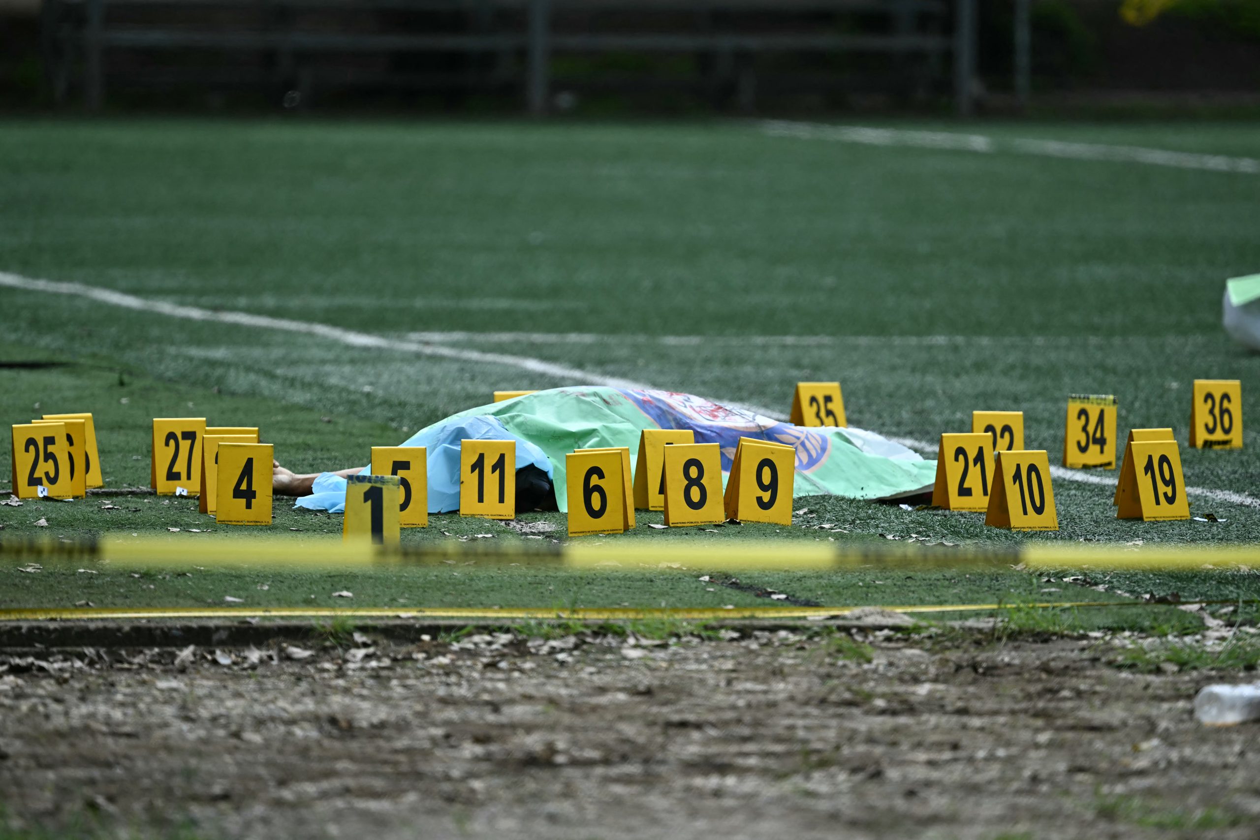 EDITORS NOTE: Graphic content / The body of lawyer Juan Francisco Solorzano Foppa lies covered on a football pitch at the Campo Marte sports complex in Guatemala City on October 17, 2026. Former Guatemalan prosecutor who denounced corruption cases and alleged links between gangs and politicians was shot dead in Guatemala City on October 17, 2026, police said. Lawyer Juan Francisco Solorzano Foppa was attacked at a football field he frequented on weekends, according to a police report, which said two "suspected perpetrators" had been detained on a preliminary basis. (Photo by Johan ORDONEZ / AFP)